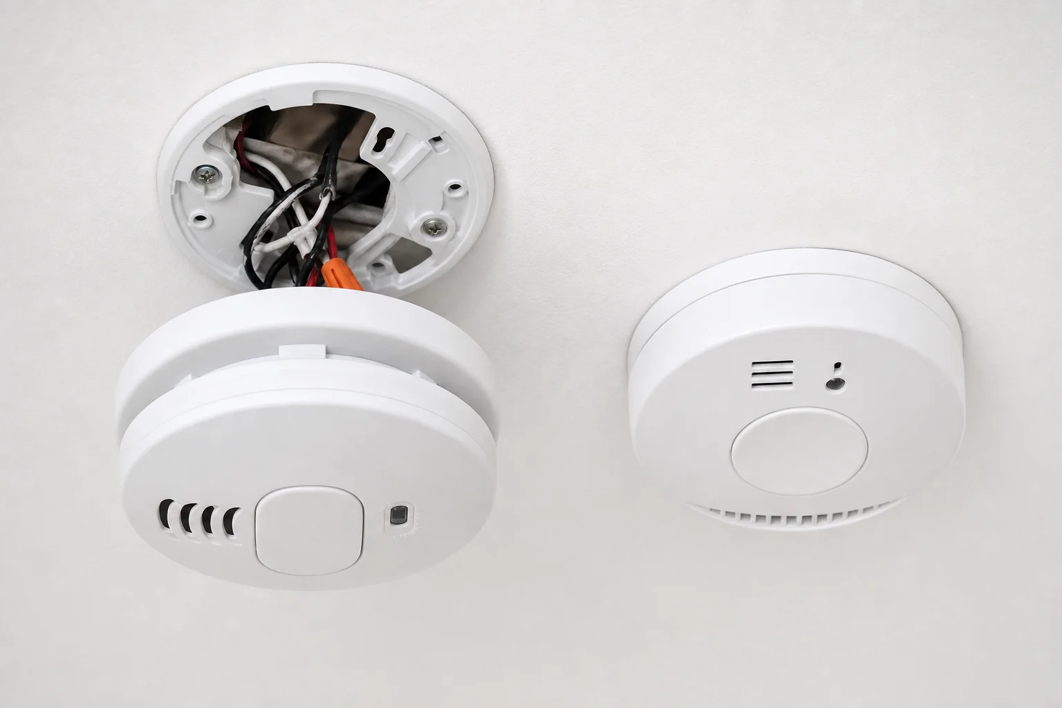 Licensed Kansas City electrician installing a hardwired smoke and carbon monoxide detector in a residential home